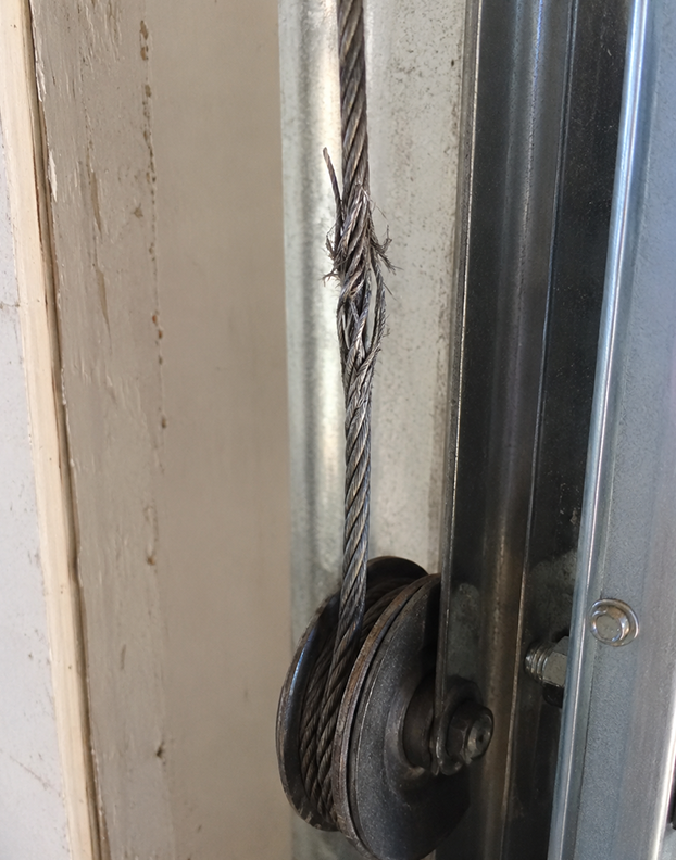 Professional fixing a damaged garage door opener during an emergency call in Denton